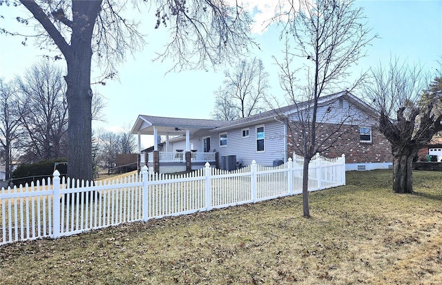 back of property with a fenced front yard, a yard, a porch, and ceiling fan