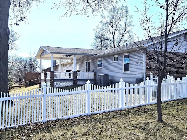 rear view of property with a ceiling fan, covered porch, and a fenced front yard