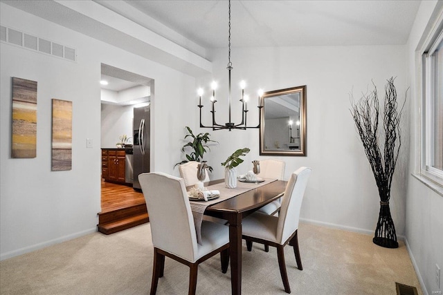 carpeted dining area with lofted ceiling and an inviting chandelier