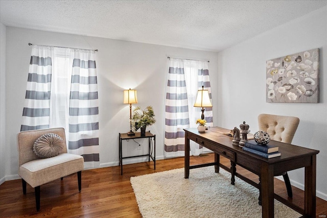 office with a healthy amount of sunlight, hardwood / wood-style flooring, and a textured ceiling