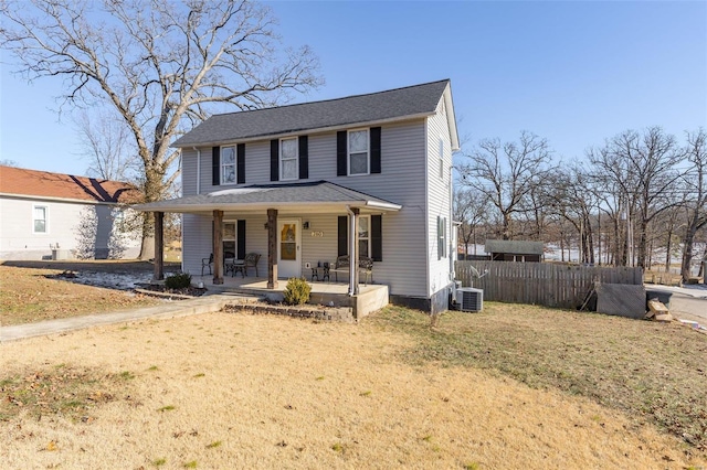 view of front of property featuring covered porch, central air condition unit, and a front yard