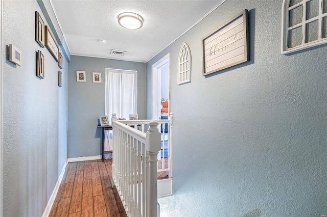 hallway with dark wood-type flooring and a textured ceiling