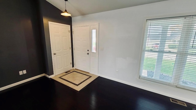 foyer entrance featuring hardwood / wood-style floors, lofted ceiling, and a healthy amount of sunlight