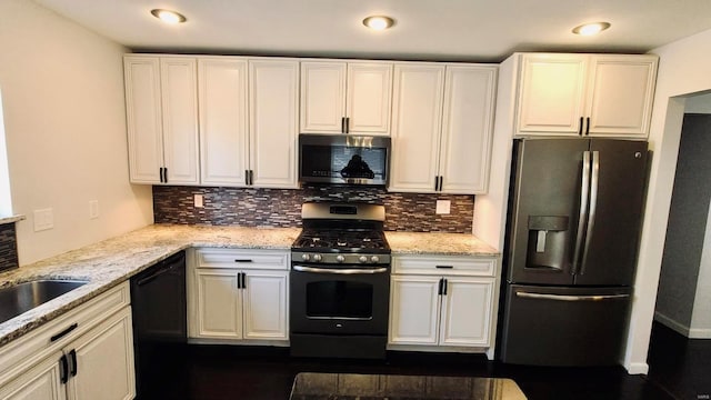 kitchen with light stone counters, white cabinets, appliances with stainless steel finishes, and tasteful backsplash