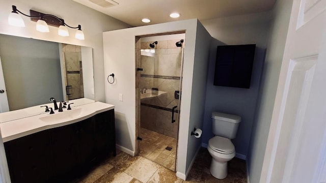 bathroom featuring vanity, toilet, and a shower with shower door