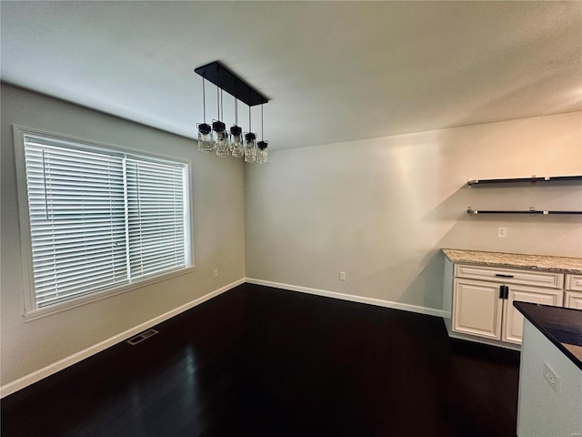 unfurnished dining area with dark hardwood / wood-style floors