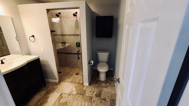 bathroom featuring toilet, a shower with shower door, and vanity