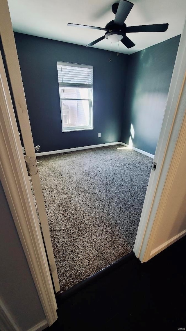 spare room with ceiling fan and carpet