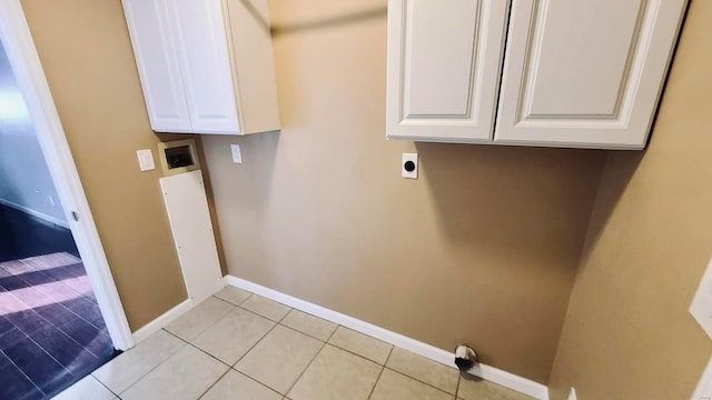 laundry area featuring hookup for a washing machine, hookup for an electric dryer, light tile patterned floors, and cabinets