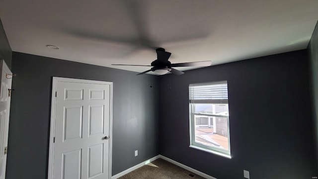 unfurnished bedroom featuring ceiling fan and carpet