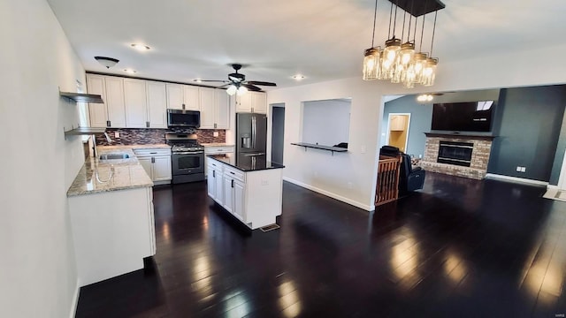 kitchen featuring hanging light fixtures, sink, white cabinets, tasteful backsplash, and stainless steel appliances