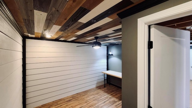 basement featuring wood walls, light hardwood / wood-style flooring, ceiling fan, and wood ceiling