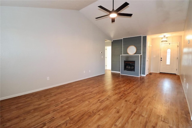 unfurnished living room with ceiling fan, high vaulted ceiling, a fireplace, and hardwood / wood-style flooring