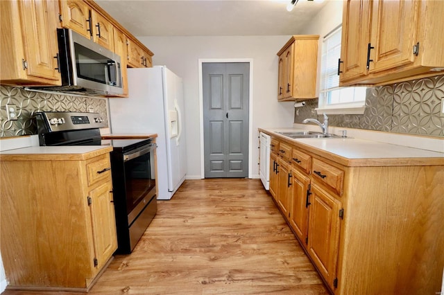 kitchen with decorative backsplash, sink, appliances with stainless steel finishes, and light wood-type flooring