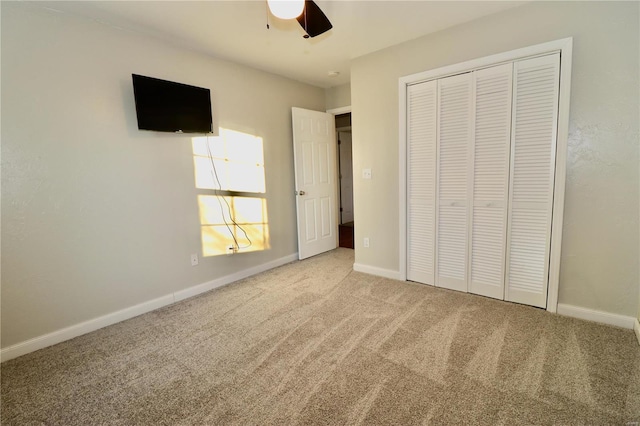 unfurnished bedroom with ceiling fan, a closet, and carpet flooring