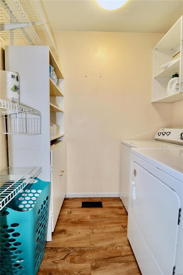 laundry area featuring light wood-type flooring and washing machine and clothes dryer