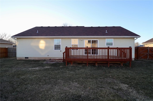 rear view of property featuring a deck and a lawn