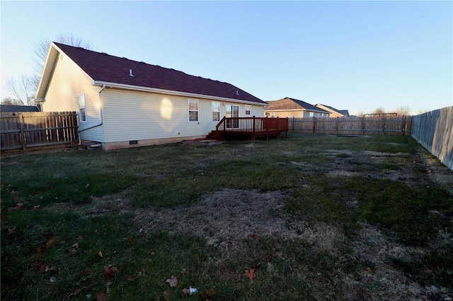 back of property with a deck and a lawn