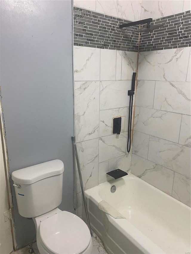 bathroom featuring tiled shower / bath combo and toilet