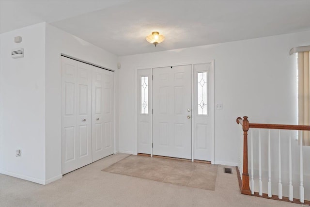 view of carpeted foyer entrance