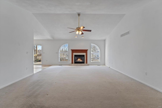 unfurnished living room with high vaulted ceiling, light colored carpet, ceiling fan, and a healthy amount of sunlight