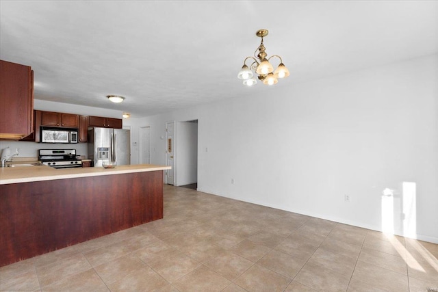 kitchen with appliances with stainless steel finishes, sink, kitchen peninsula, pendant lighting, and an inviting chandelier