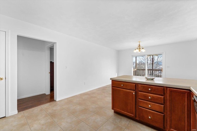 kitchen featuring a notable chandelier, light tile patterned floors, pendant lighting, and black dishwasher