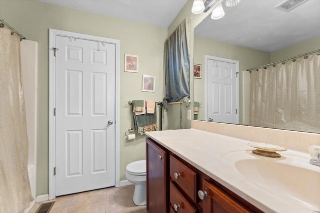 bathroom with toilet, vanity, and tile patterned flooring