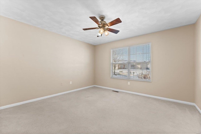 spare room featuring ceiling fan and light colored carpet