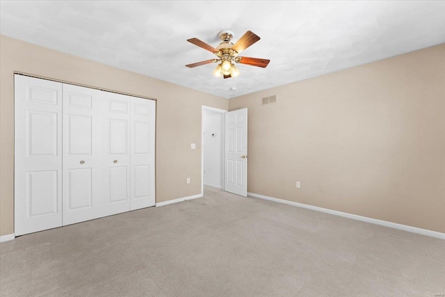 unfurnished bedroom with a closet, ceiling fan, and light colored carpet