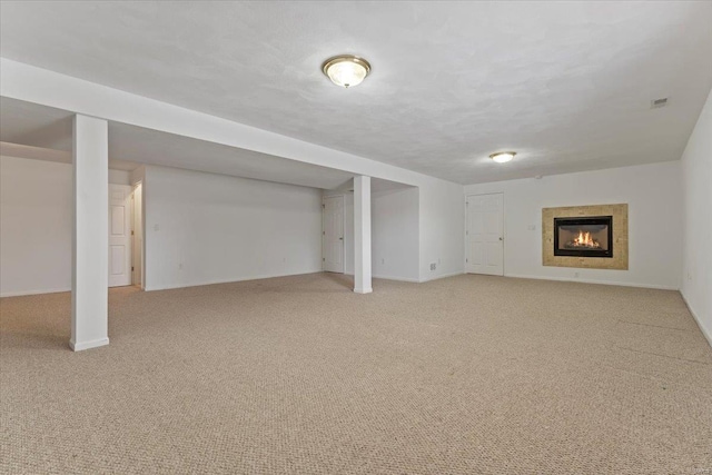 basement featuring light carpet and a textured ceiling