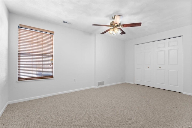 unfurnished bedroom with a closet, ceiling fan, and carpet floors