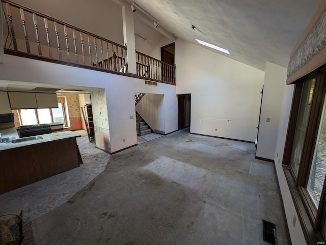 unfurnished living room featuring high vaulted ceiling