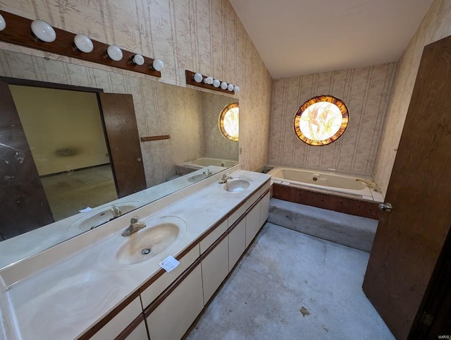 bathroom featuring lofted ceiling, vanity, and a tub to relax in