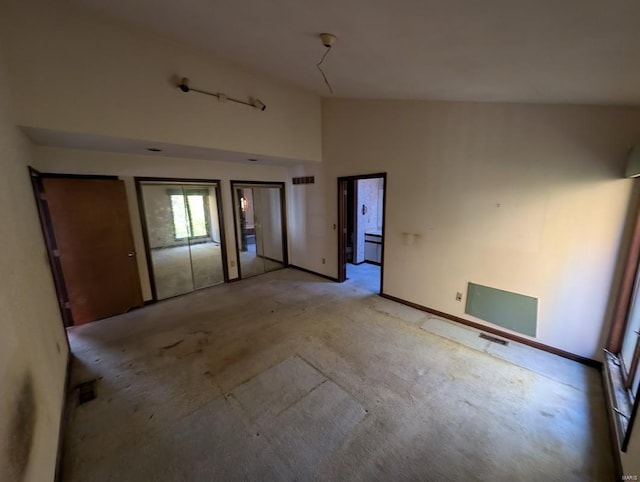 unfurnished room with high vaulted ceiling