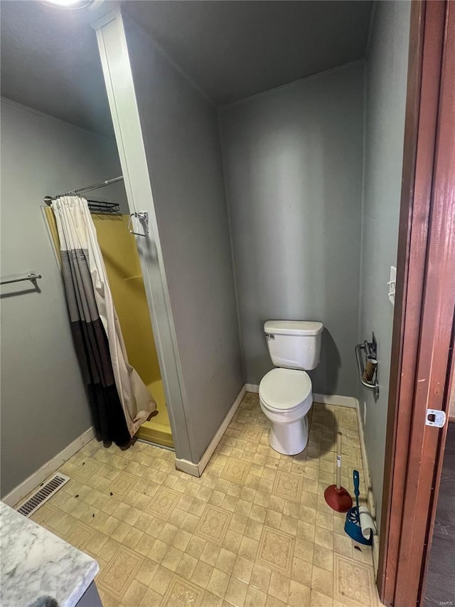 bathroom featuring curtained shower and toilet