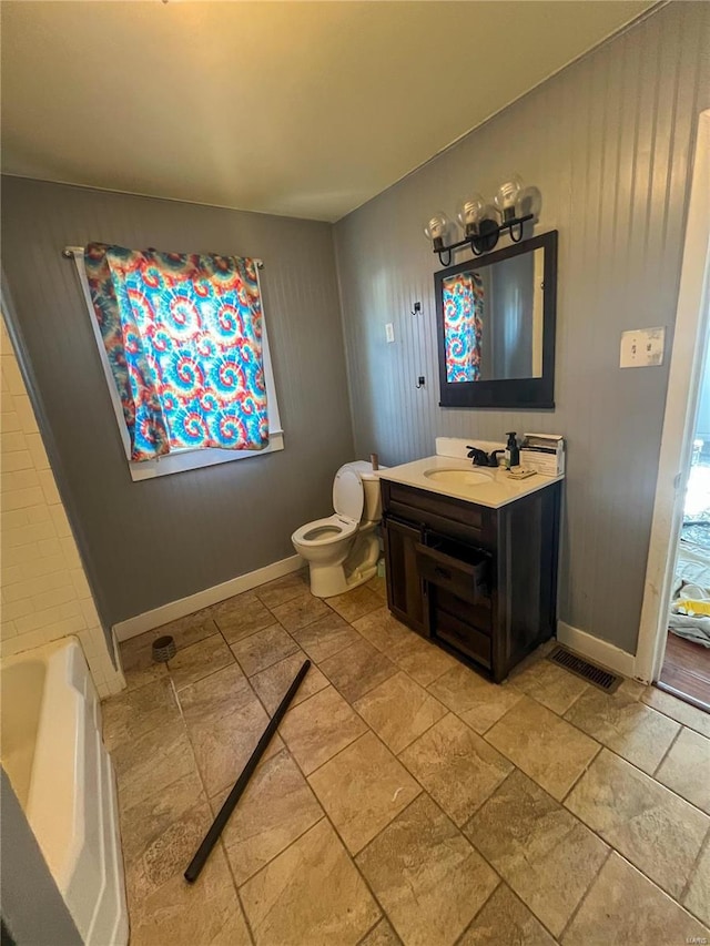 bathroom featuring vanity, toilet, and a tub