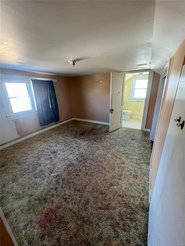 unfurnished room featuring vaulted ceiling, a wealth of natural light, and carpet flooring