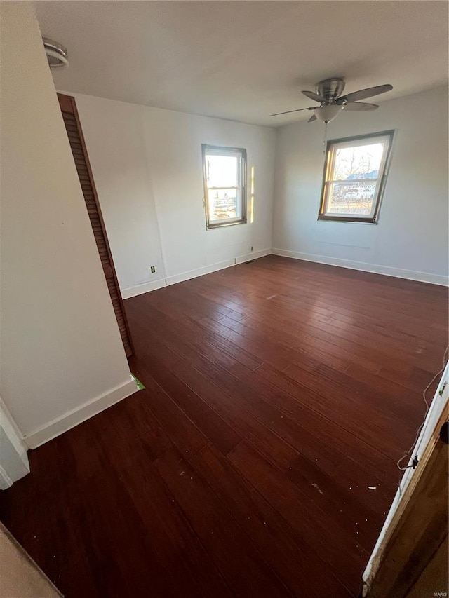 empty room featuring ceiling fan and dark wood-type flooring