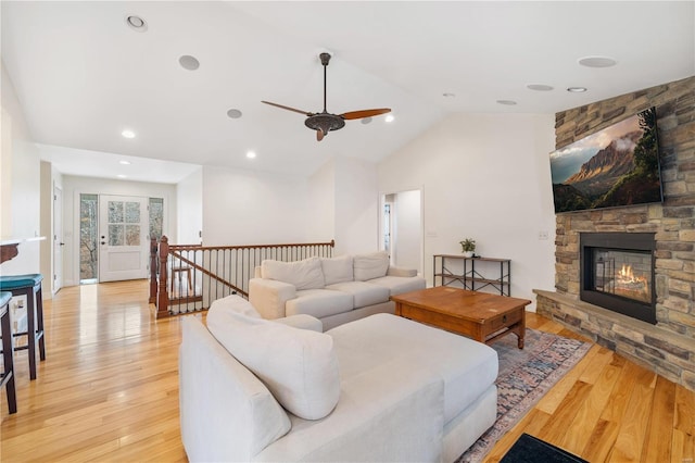 living room featuring a fireplace, light hardwood / wood-style flooring, and vaulted ceiling