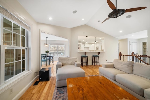 living room with vaulted ceiling, ceiling fan, and light hardwood / wood-style floors