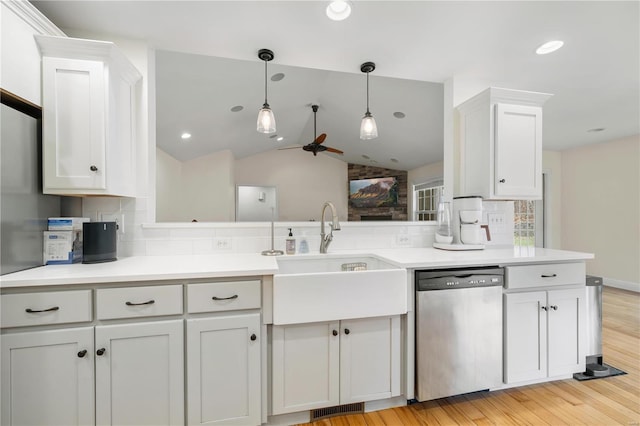 kitchen with decorative light fixtures, white cabinetry, sink, stainless steel dishwasher, and light hardwood / wood-style floors