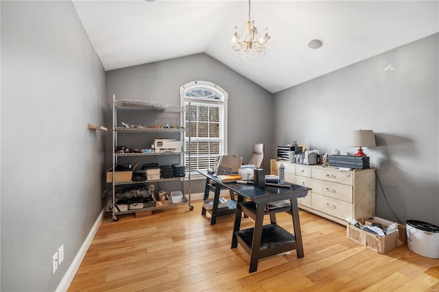 office area featuring lofted ceiling, light wood-type flooring, and a chandelier