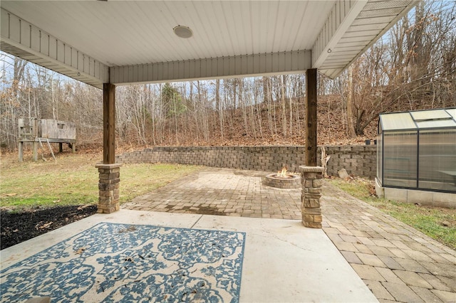 view of patio / terrace with an outbuilding and a fire pit