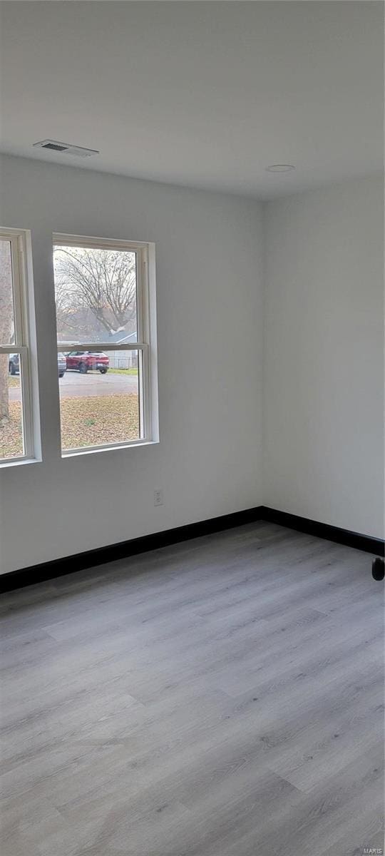 unfurnished room with light hardwood / wood-style floors and a healthy amount of sunlight