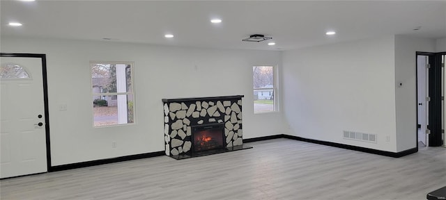 living room featuring light wood-type flooring and a fireplace