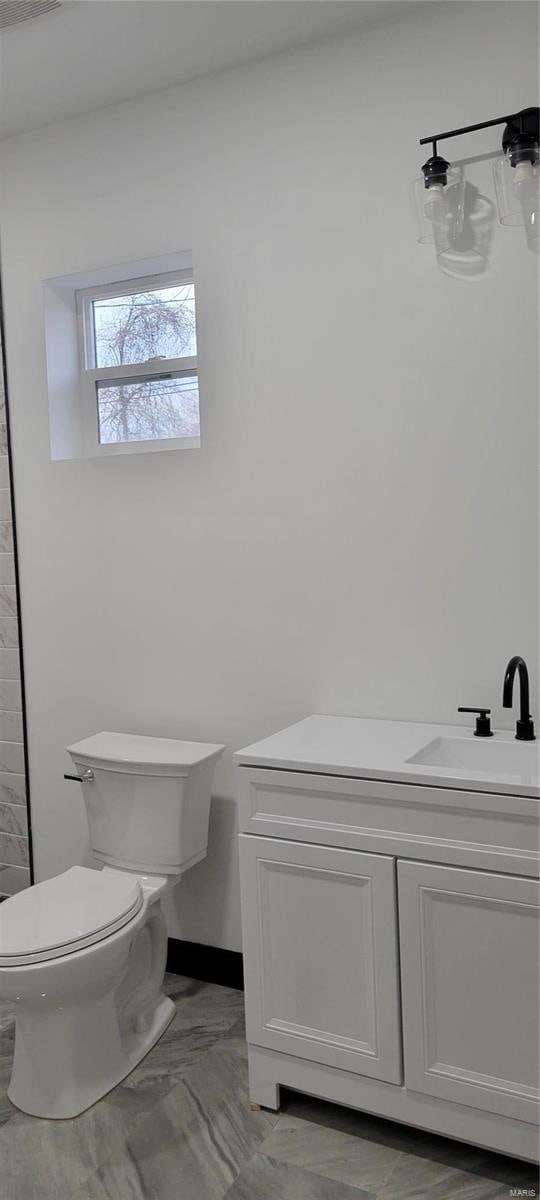 bathroom featuring toilet and vanity