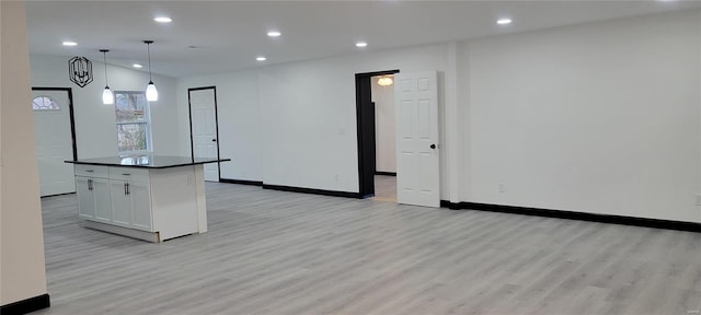 kitchen featuring light hardwood / wood-style flooring, pendant lighting, white cabinetry, and a center island