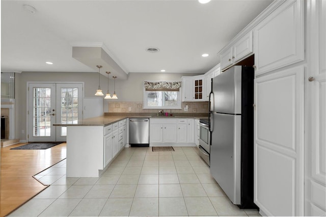 kitchen with visible vents, appliances with stainless steel finishes, french doors, a peninsula, and light tile patterned flooring