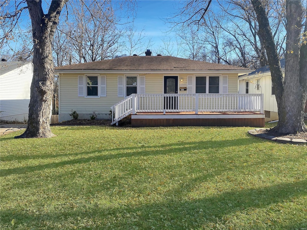 view of front of property with a deck and a front yard